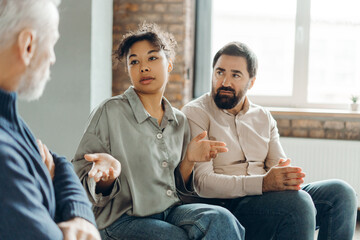 Patients discussing problems with senior male psychologist during therapy session