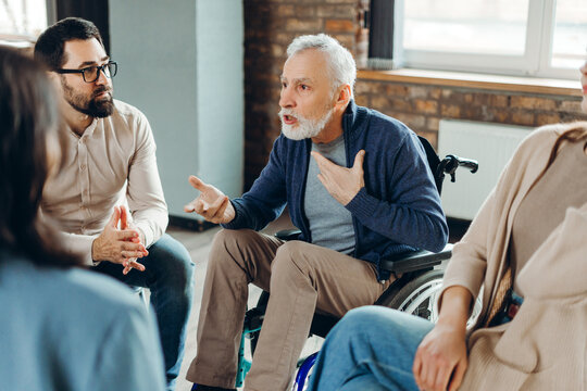Senior man in wheelchair sharing his story during group therapy session