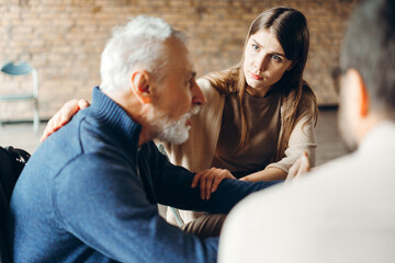 Psychologist comforting senior man during therapy session