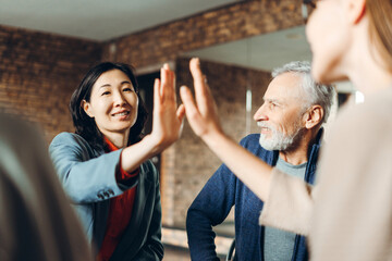 Business team giving high five after successful meeting