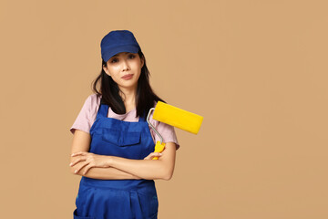 Female Asian painter with roller on brown background