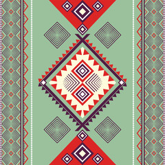 Red and green geometric ethnic patterned background. Seamless striped ornament in Aztec style. Boho style. Navajo style. Native ethnic style. For wallpaper, backdrop, and edge fabric.