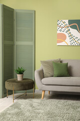 Stylish interior of modern living room near green wall