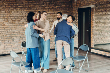 Diverse people hugging in support group session