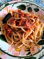 evocative close-up image of a homemade spaghetti with tomato sauce and mussels
