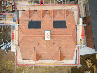 Drone high up view of a completed semi detached house roof showing the new installed solar panels....