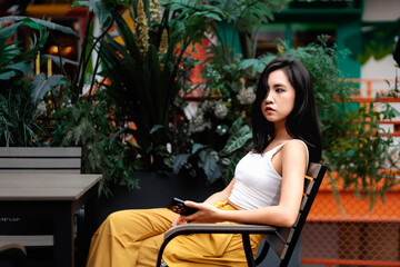 Vibrant young Asian woman using cell phone outdoors