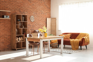 Interior of comfortable living room with table, sofa, chairs and shelving unit