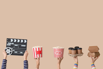 Many hands with movie clapper, buckets of popcorn and coffee on beige background