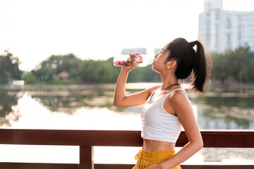 Energetic girl after exercise drinks water to rehydrate