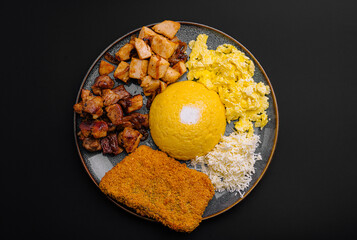 Assorted Romanian-style meal with creamy polenta, scrambled eggs, grilled meats, grated cheese, and...