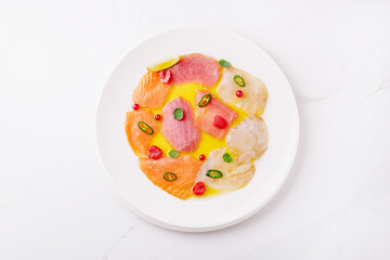 Citrus-infused sashimi platter served on a white plate with garnishes