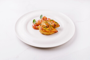 Roasted chicken with cherry tomatoes on a white plate