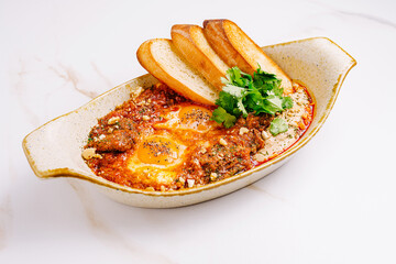 Delicious shakshuka served with crusty bread and fresh herbs for breakfast