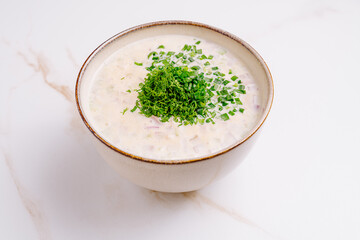 Delicious yogurt-based soup with fresh herbs served in a bowl