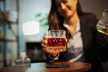 Closeup business woman holding a glass of whiskey