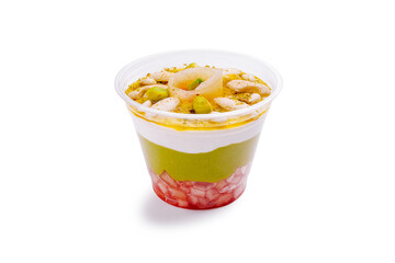 Colorful dessert layered with fruits and cream served in a clear cup