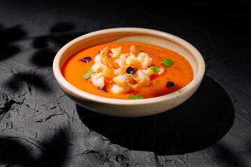 Savory shrimp bisque served in a bowl on a textured dark surface