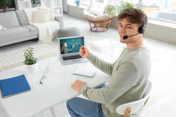 Male student in headset studying Math with online teacher at home