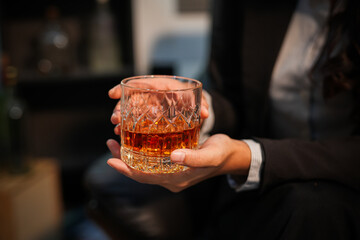 Closeup business woman holding a glass of whiskey