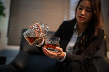  Closeup business woman holding a glass of whiskey