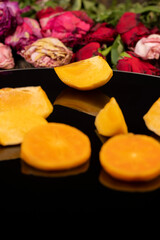 peeled ripe juicy persimmons ripe orange persimmons are reflected on the black mirror surface