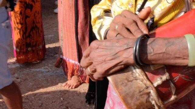 Closeup of Timorese woman wearing traditional tais clothing with cultural drum in Timor-Leste, Southeast Asia
