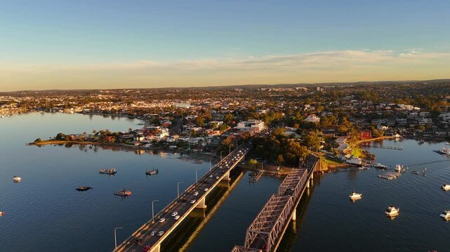 Wide aerial of Tom Uglys Bridge near Sylvania during golden hour with traffic and water below, Sydney NSW Australia