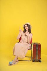 Traveler Sitting on a Chair with Luggage Against a Yellow Background