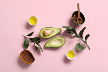 Composition with ripe avocado, bowls of oil and flax seeds on pink background