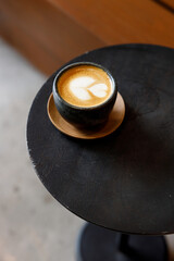 Cup of milk latte coffee on table by the street.