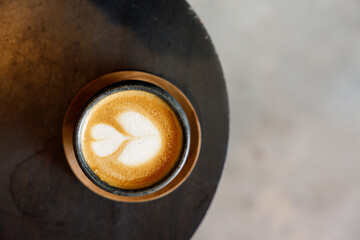 Cup of milk latte coffee on table by the street.