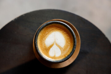 Cup of milk latte coffee on table by the street.