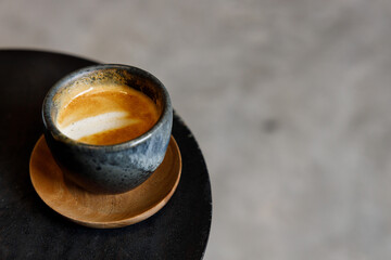 Cup of milk latte coffee on table by the street.