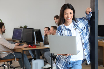 Female programmer with laptop in office