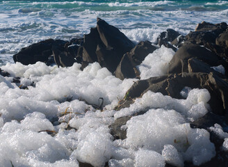 Accumulation of foam produced from toxic algae among rocks in Penneshaw, Kangaroo Island, Australia