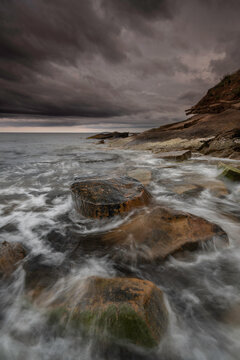 The coastline of Crail, Fife, Scotland with petrified tree trunks in the water.