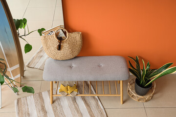 Soft bench with bag and flip-flops in hallway interior