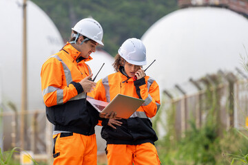 Team of Engineers Conducting Operations at Oil Storage Field Industrial Site, Engineers Collaborating at Industrial Site with Storage Tanks, Industrial Workers with Laptop and Walkie-Talkies at Site