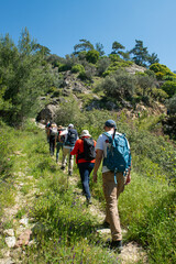 People trekking in Latmos mountains in spring. Latmos Caria trekking route. Latmos trekking route among historical ruins. Hiking from Latmos Mountain to Lake Bafa. Walking by Lake Bafa.
