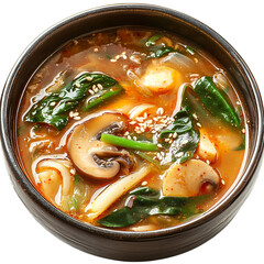 Close up of a bowl of soup with mushrooms and spinach on a black surface