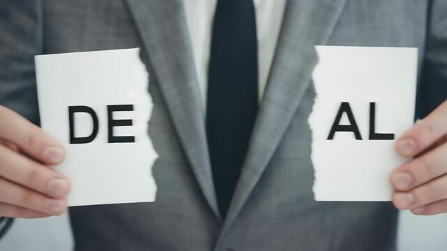 Hands of businessperson holding a paper with the inscription word "Deal" split over two pages, Businessperson ripping up business deal, Failure business, breaking contract deal concept	