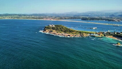 Fototapeta premium This aerial view captures a stunning coastal island surrounded by clear blue waters, creating a serene paradise