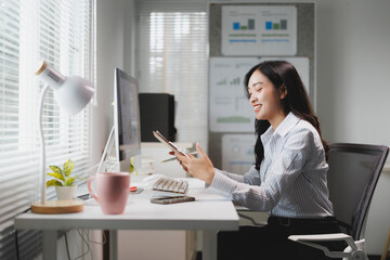 Asian businesswoman working with computer and documents at office desk