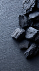 Dark textured stones arranged on a slate surface, showcasing natural patterns and colors, creating a visually striking and calming atmosphere for design and decoration purposes
