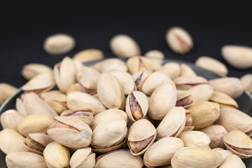Salted Pistachios for Beer, Macro, on black Background of a Beer Snack of Salted Pistachio Nuts.