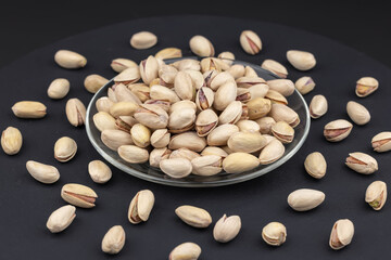 Salted Pistachios for Beer, Macro, on black Background of a Beer Snack of Salted Pistachio Nuts.