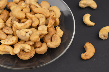 Salted cashew nuts in dessert plate on black table