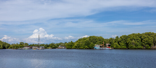 A panoramic view of a fishing village and mangrove forest along a river in Kuala Penyu, Sabah,...