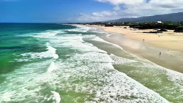 A stunning aerial view showcases the mesmerizing beach waves, vibrant blue water, and a sunlit coastline retreat